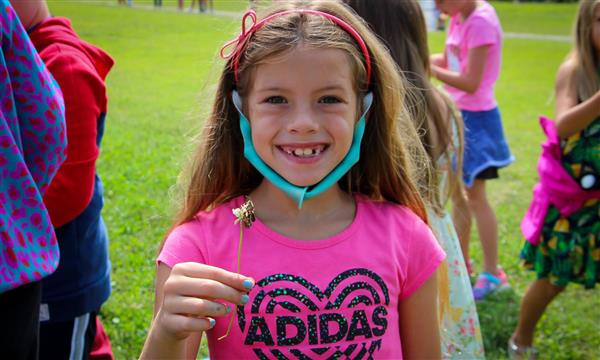 Girl has butterfly on flower